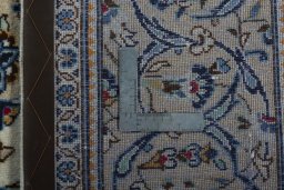 Backside of handmade 2000s Kashan rug showing knot structure and weave density