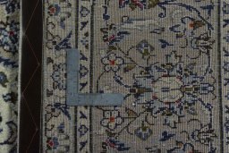 Backside of handmade 2000s Kashan rug showing knot structure and weave density