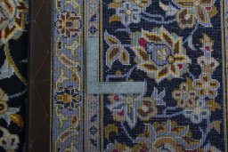 Backside of handmade 2000s Kashan rug showing knot structure and weave density