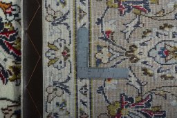 Backside of handmade 2000s Kashan rug showing knot structure and weave density
