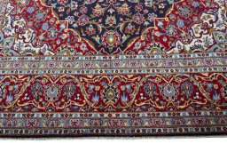 Corner detail of 2000s Kashan rug showing border pattern and Wool pile