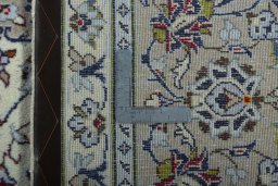 Backside of handmade 2000s Kashan rug showing knot structure and weave density