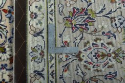 Backside of handmade 2000s Kashan rug showing knot structure and weave density