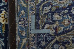 Backside of handmade 2000s Kashan rug showing knot structure and weave density