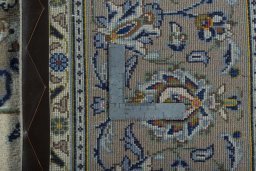 Backside of handmade 2000s Kashan rug showing knot structure and weave density