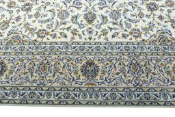 Corner detail of 2000s Kashan rug showing border pattern and Wool pile
