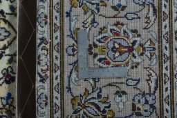 Backside of handmade 2000s Kashan rug showing knot structure and weave density
