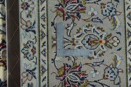 Backside of handmade 2000s Kashan rug showing knot structure and weave density