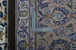 Backside of handmade 2000s Kashan rug showing knot structure and weave density