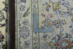 Backside of handmade 2000s Kashan rug showing knot structure and weave density