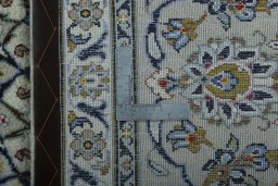 Backside of handmade 2000s Kashan rug showing knot structure and weave density