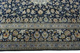 Corner detail of 2000s Kashan rug showing border pattern and Wool pile