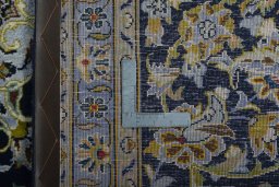 Backside of handmade 2000s Kashan rug showing knot structure and weave density