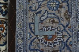 Backside of handmade 2000s Kashan rug showing knot structure and weave density