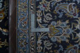 Backside of handmade 2000s Kashan rug showing knot structure and weave density