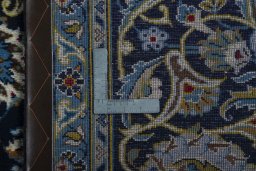 Backside of handmade 2000s Kashan rug showing knot structure and weave density