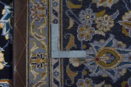Backside of handmade 2000s Kashan rug showing knot structure and weave density