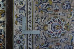 Backside of handmade 2000s Kashan rug showing knot structure and weave density