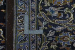 Backside of handmade 2000s Kashan rug showing knot structure and weave density