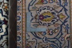 Backside of handmade 2000s Kashan rug showing knot structure and weave density