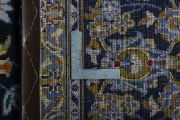 Backside of handmade 2000s Kashan rug showing knot structure and weave density