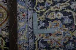 Backside of handmade 2000s Kashan rug showing knot structure and weave density