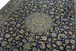 Backside of handmade 2000s Kashan rug showing knot structure and weave density