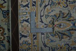Backside of handmade 1970s Kashan rug showing knot structure and weave density