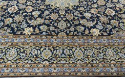 Corner detail of 2000s Kashan rug showing border pattern and Wool pile