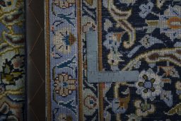 Backside of handmade 2000s Kashan rug showing knot structure and weave density