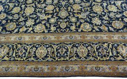 Corner detail of 2000s Kashan rug showing border pattern and Wool pile