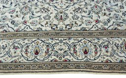 Corner detail of 2000s Kashan rug showing border pattern and Wool pile