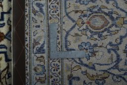 Backside of handmade 2000s Kashan rug showing knot structure and weave density
