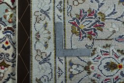 Backside of handmade 2000s Kashan rug showing knot structure and weave density