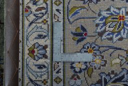 Backside of handmade 2000s Kashan rug showing knot structure and weave density