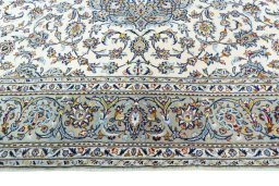 Corner detail of 2000s Kashan rug showing border pattern and Wool pile