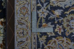 Backside of handmade 2000s Kashan rug showing knot structure and weave density
