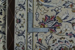 Backside of handmade 2000s Kashan rug showing knot structure and weave density