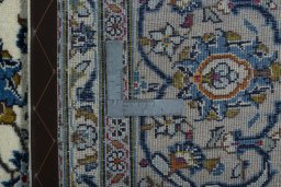 Backside of handmade 2000s Kashan rug showing knot structure and weave density