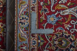 Backside of handmade 2000s Kashan rug showing knot structure and weave density