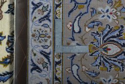 Backside of handmade 2000s Kashan rug showing knot structure and weave density