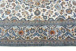 Corner detail of 2000s Kashan rug showing border pattern and Wool pile