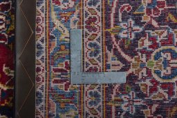 Backside of handmade 2000s Kashan rug showing knot structure and weave density