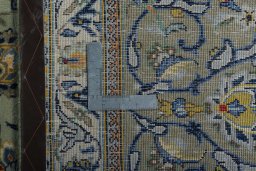 Backside of handmade 2000s Kashan rug showing knot structure and weave density