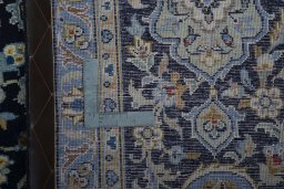 Backside of handmade 2000s Kashan rug showing knot structure and weave density