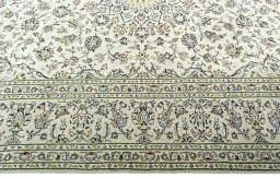 Corner detail of 2000s Kashan rug showing border pattern and Wool pile