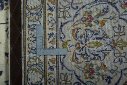 Backside of handmade 2000s Kashan rug showing knot structure and weave density