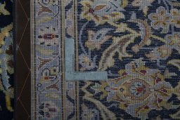 Backside of handmade 1970s Kashan rug showing knot structure and weave density