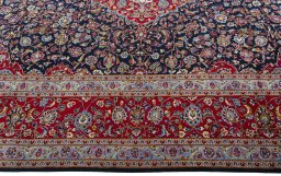Corner detail of 2000s Kashan rug showing border pattern and Wool pile