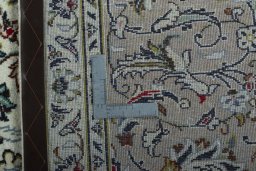 Backside of handmade 2000s Kashan rug showing knot structure and weave density